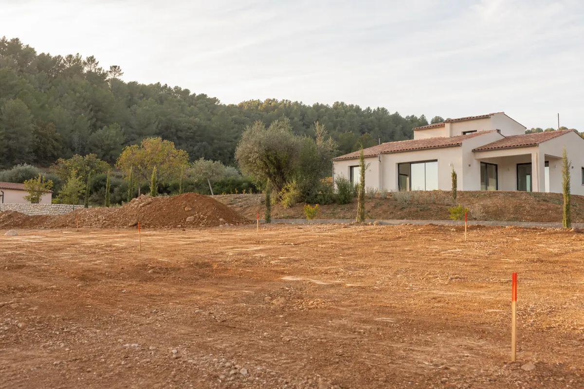 Terrain constructible à Saint-Cannat avec piquets de bornage, base du budget construction maison